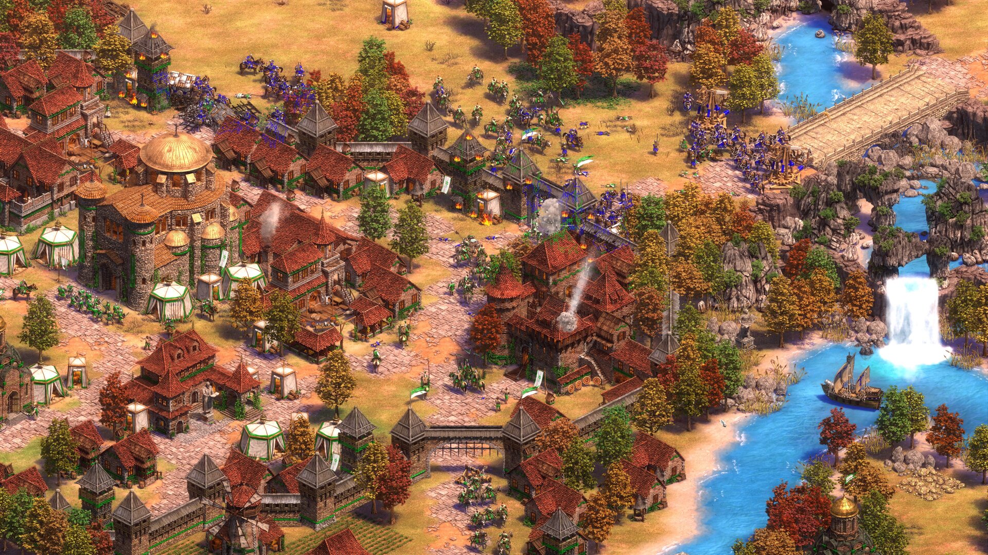 Exércitos azuis e verdes combatem ao redor de uma cidade murada de Age of Empires II, com cavalaria, infantaria e máquinas de cerco próximas a uma ponte.